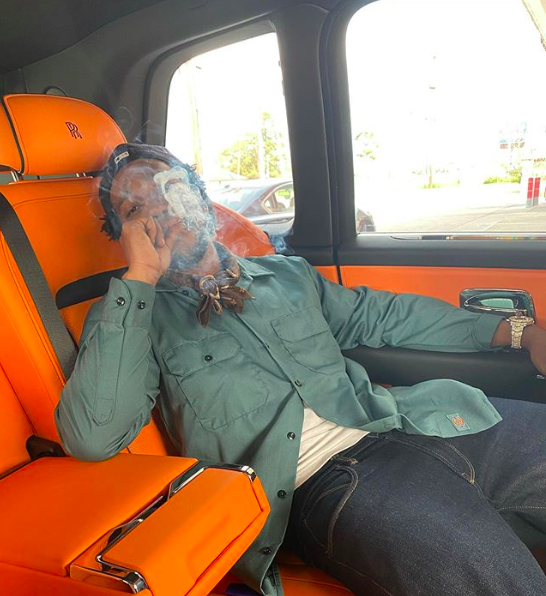 Curren$y smoking in a Rolls Royce